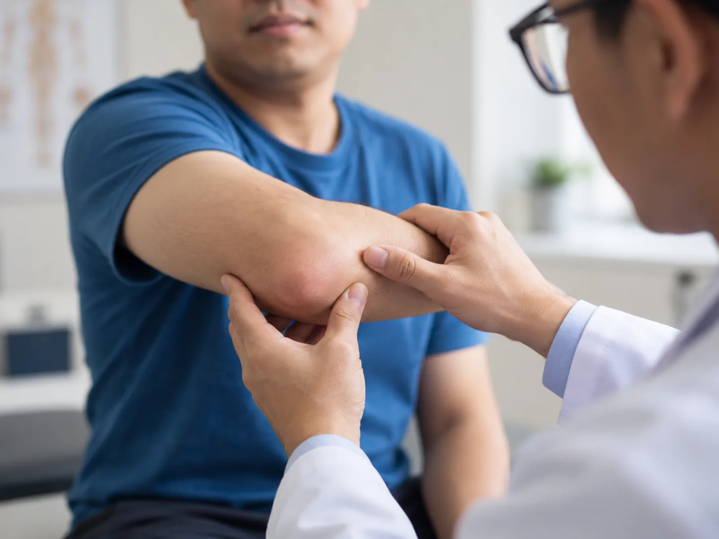 Doctor examining a patient’s arm and elbow for pain during a medical visit