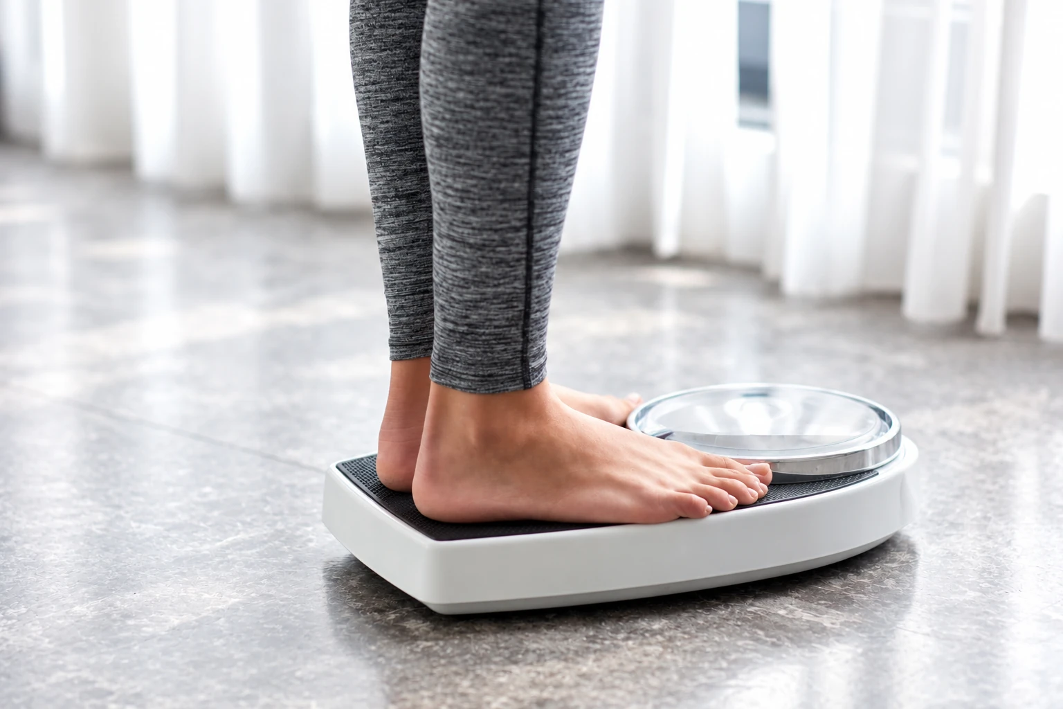 Person standing on a scale to track weight change