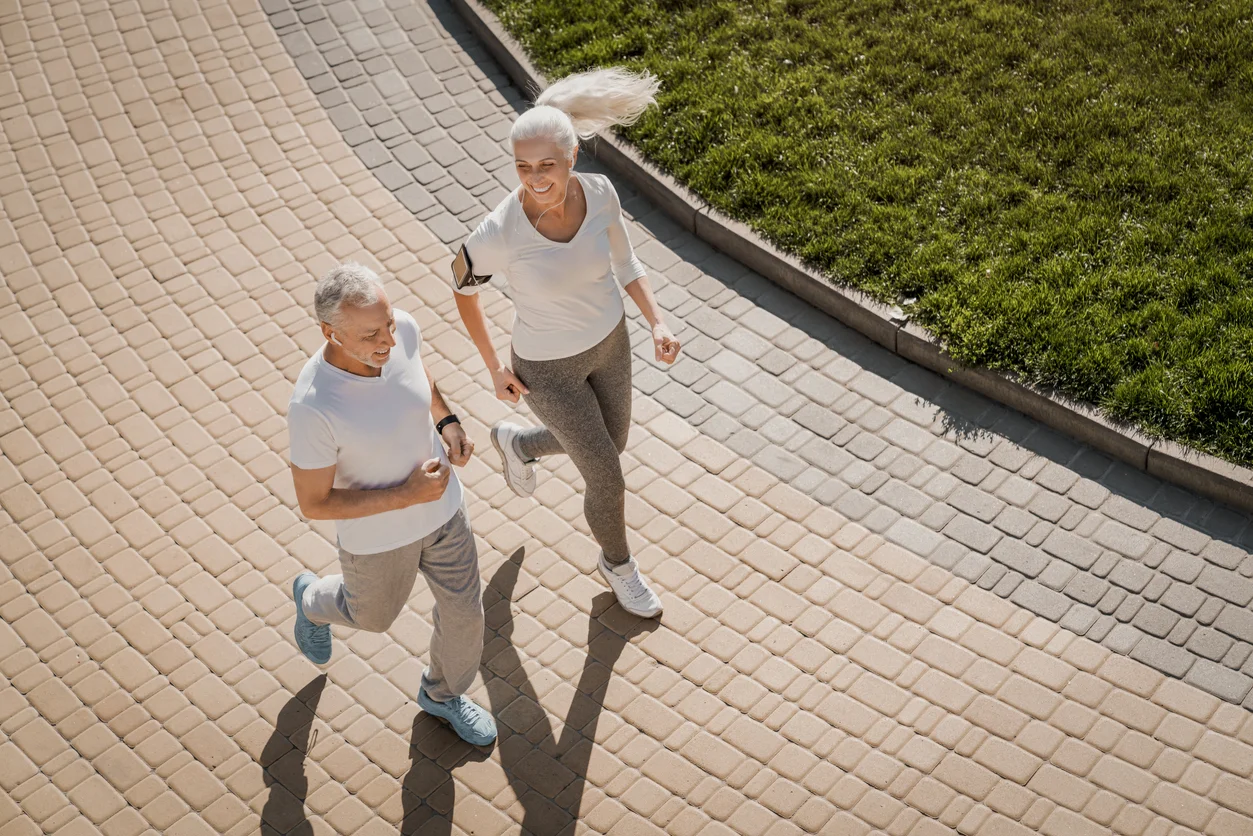 Active senior couple jogging outdoors as part of healthy lifestyle and cardiovascular fitness routine